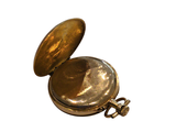 a gold pocket watch sitting on a white surface