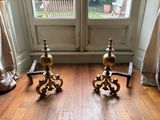 two candles that are sitting on the floor in front of a window