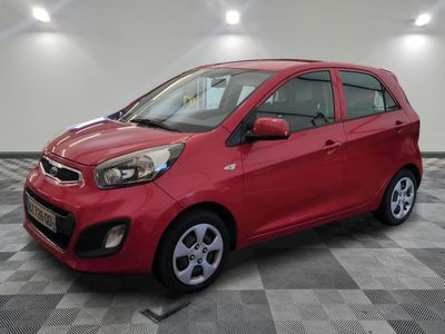 a red car is parked in a room with a checkered floor