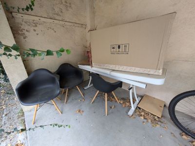 trois chaises noires et une table blanche dans un garage
