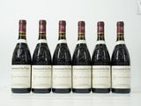 six bouteilles de vin sont alignées sur une table