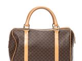 a brown and tan handbag sitting on top of a white surface