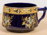 a blue cup with gold and blue flowers on it