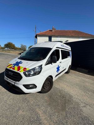 a white van parked in front of a building with an ambulance on the side of it