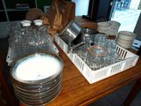 a wooden table topped with dishes and glasses on it