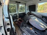 une camionnette blanche avec une planche de surf à l'arrière