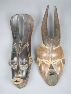 une paire de masques africains sur fond blanc avec un fond gris