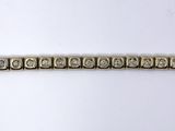 a close up of a gold and diamond bracelet on a white surface