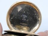 a close up of a person holding a pocket watch