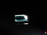 an image of a green tourmaline in a dark room