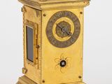 une horloge en or posée sur un socle