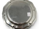 a silver plate on a white surface with a tag on it