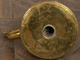 a gold vase sitting on a wooden floor