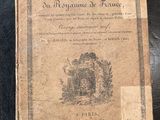 un vieux livre posé sur une table à côté d'une table noire