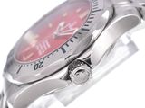a close up of a wrist watch with a red dial