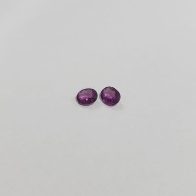 a pair of purple sapphires on a white surface