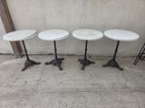 three white marble topped tables sitting on top of a sidewalk