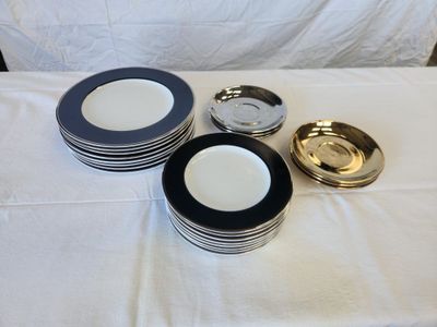 many plates and bowls on a table with a white table cloth