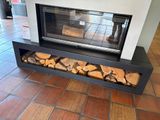 a fire place with logs stacked on the floor