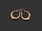 a pair of gold hoop earrings on a black background