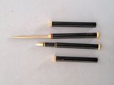 four pens are lined up in a row on a white surface