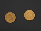 two gold coins sitting side by side on a black surface