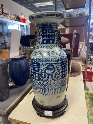 un vase bleu et blanc posé sur une table dans un magasin