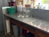 a counter with a lot of empty glasses on it
