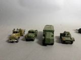 Plusieurs véhicules militaires miniatures sont alignés en rang sur une table