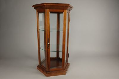 une vieille vitrine en bois avec des étagères en verre et une porte