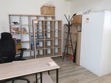 a desk with a chair and a refrigerator in a room