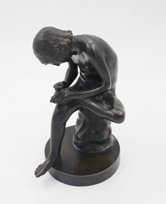 statue représentant un homme assis sur un tabouret, la tête entre les mains