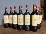 six bottles of wine are lined up on a wooden table