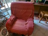 un fauteuil rose dans un salon doté d'une grande fenêtre