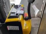 a yellow and black fork lifter sitting next to a door
