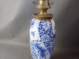 un vase bleu et blanc posé sur un socle doré