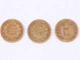 three different types of gold coins on a white surface