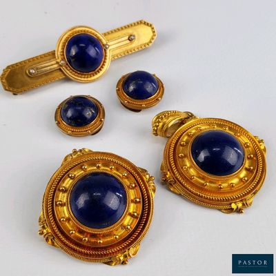 une photo d'un ensemble de bijoux dorés et bleus posé sur une surface blanche