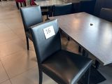une table et des chaises dans un restaurant, avec une étiquette de prix posée sur la table