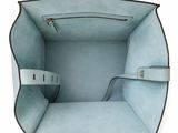 the inside of a light blue handbag with two handles