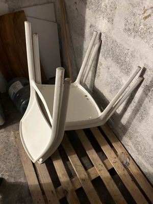 une pile de chaises en plastique blanc posées sur une palette