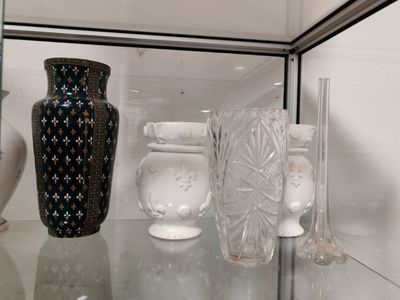 une étagère en verre sur laquelle sont posés des vases et d'autres objets en verre