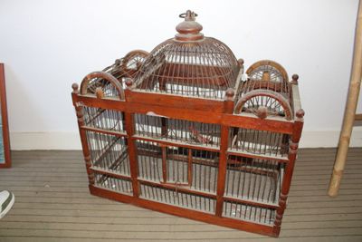 une cage à oiseaux en bois contenant deux oiseaux