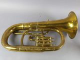 an old brass trumpet sitting on top of a white table