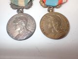 two medals are sitting next to each other on a white surface