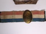 une ceinture avec une boucle dorée et une ceinture marron avec une bande bleue, blanche et rouge