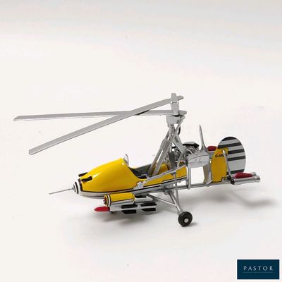 une petite maquette d'hélicoptère jaune posée sur une surface blanche