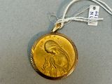 une médaille d'or avec la photo d'une femme dessus