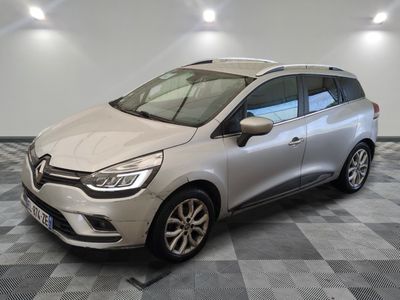 une voiture argentée garée dans un garage au sol en damier