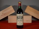 a bottle of wine sitting on a table next to a wooden box
